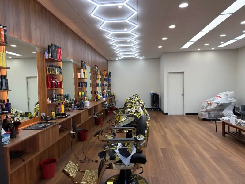Five barber chairs along the timber mirror wall after the renovation