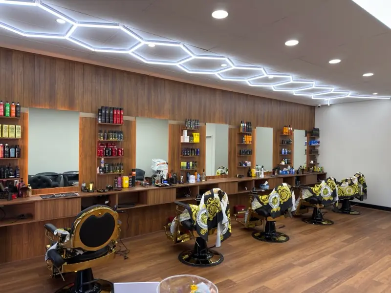 The row of barber chairs and timber mirror wall inside Royal Fade Barbers at City West, West Perth